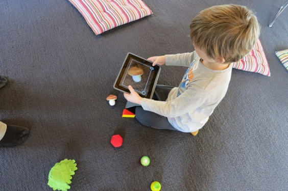 Ein Kind in spielerischem Umgang mit einem Tablet